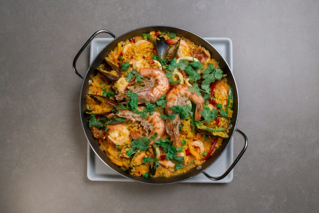 Een luxe paella met kreeft en zeevruchten geserveerd