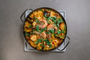 Een luxe paella met kreeft en zeevruchten geserveerd