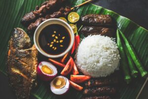 Tafel bedekt met bananenbladeren vol Filipijns eten in Boodle Fight-stijl